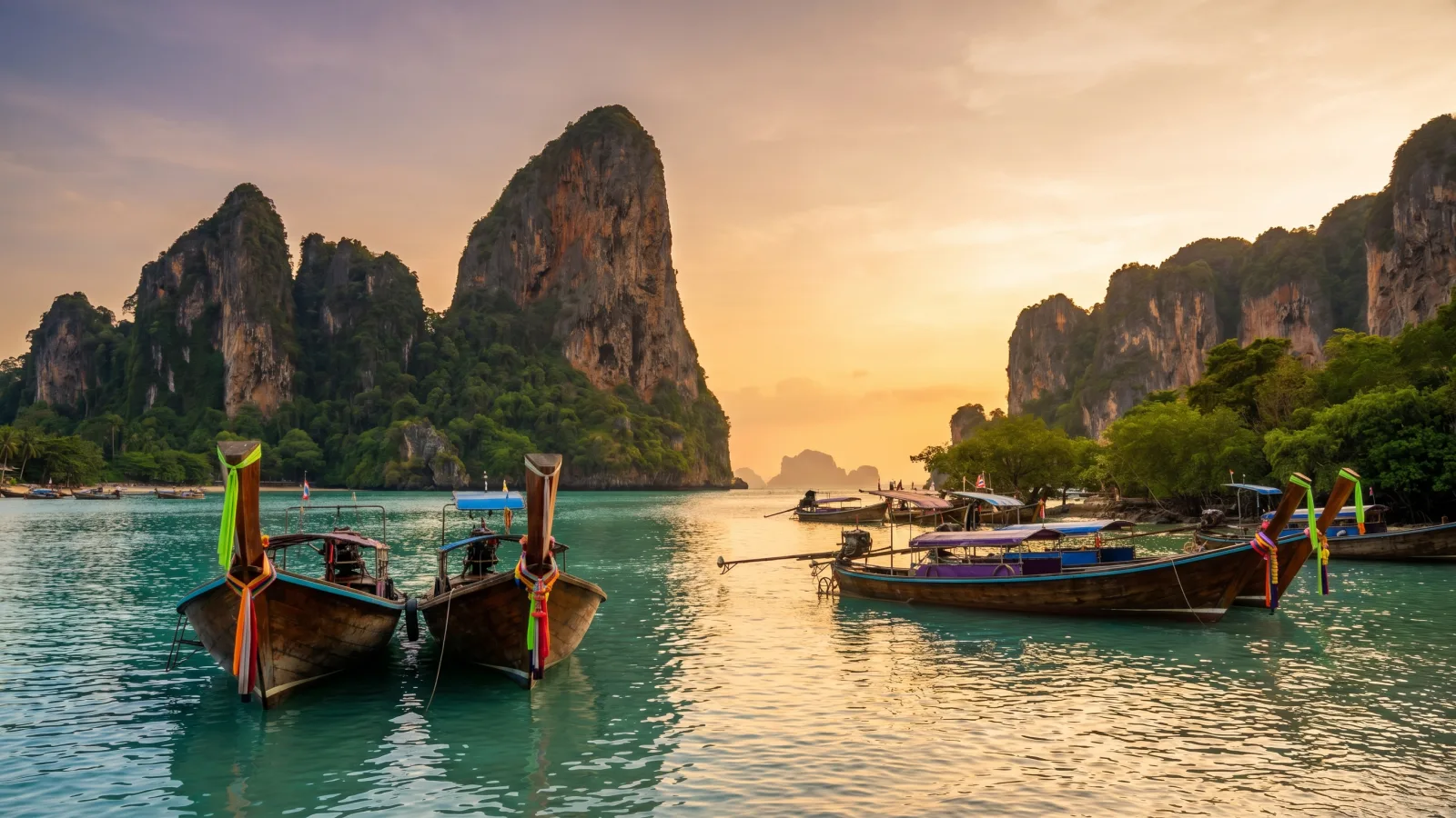 Baie tropicale du sud de la Thailande avec bateaux longue-queue au coucher du soleil